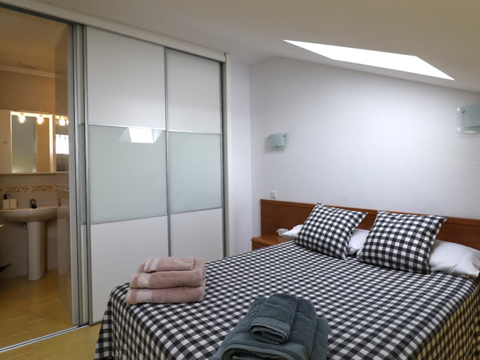 Dormitorio con baño en suite y claraboya