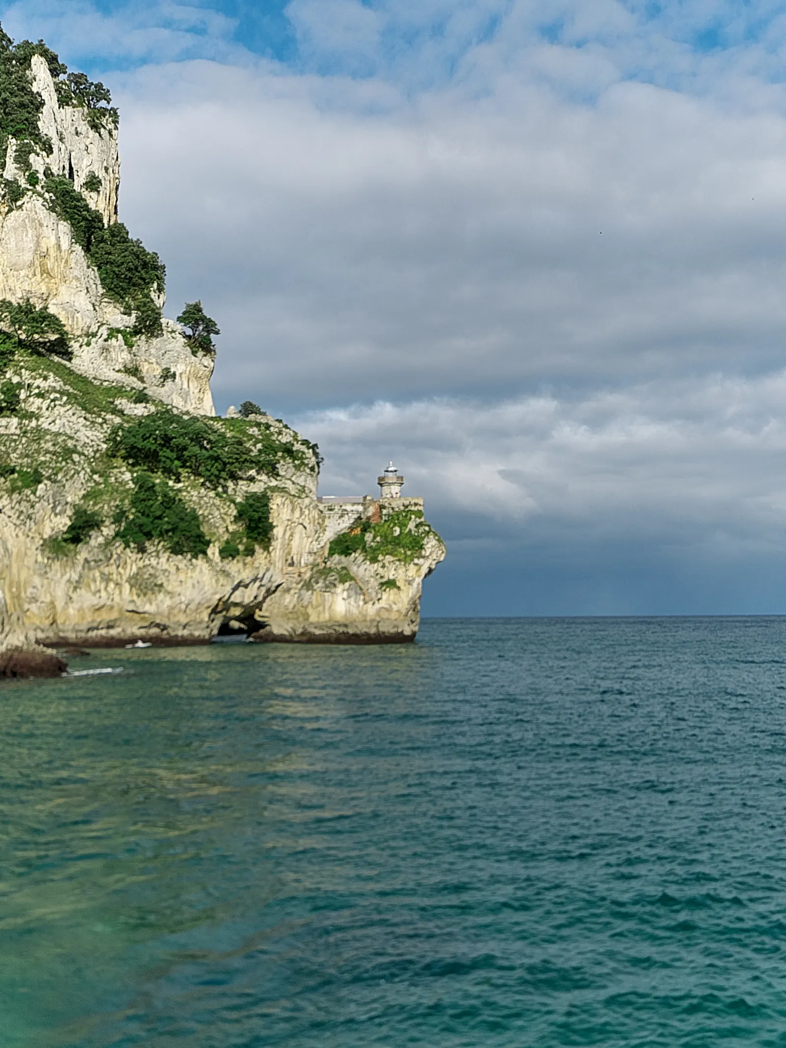 Los acantilados del monte Buciero cayendo al mar, con el Faro del Caballo asomando